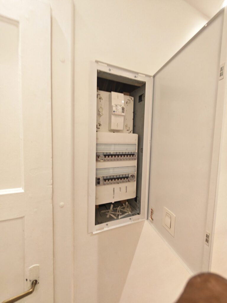 Tableau électrique en applique dans un couloir de logement